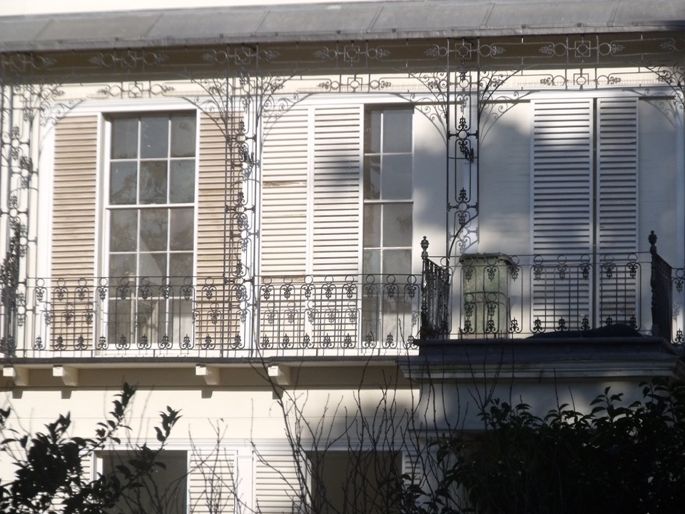 Iron balconies and painted shutters on a white rendered block of flats at Leamington Spa